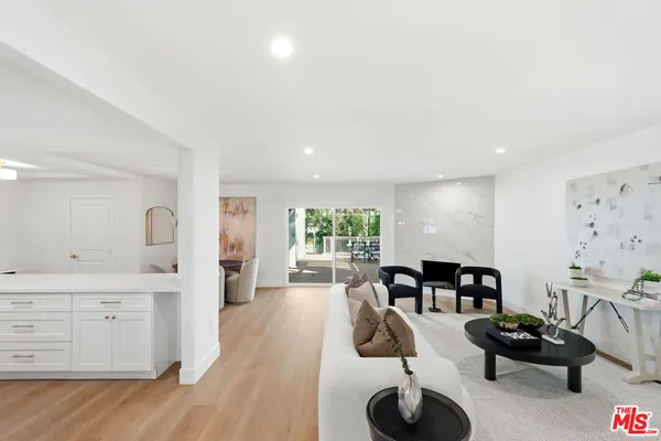 a living room with furniture a flat screen tv and a large window