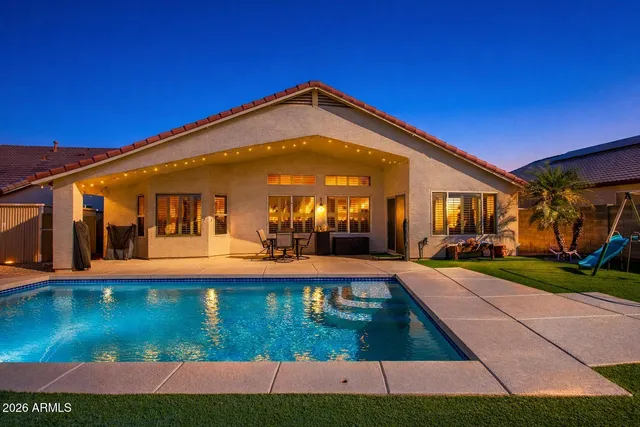 a view of a house with swimming pool and sitting area
