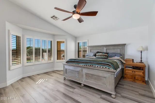 a kitchen with stainless steel appliances kitchen island granite countertop a sink and a wooden floors