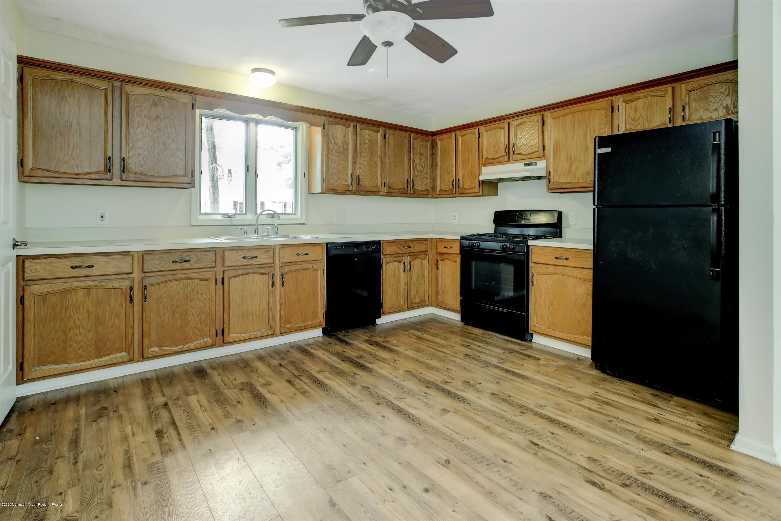 474 E Road Belford, NJ 07718 - Photo 17 of 32 a kitchen with granite countertop stainless steel appliances a refrigerator cabinets and wooden floor