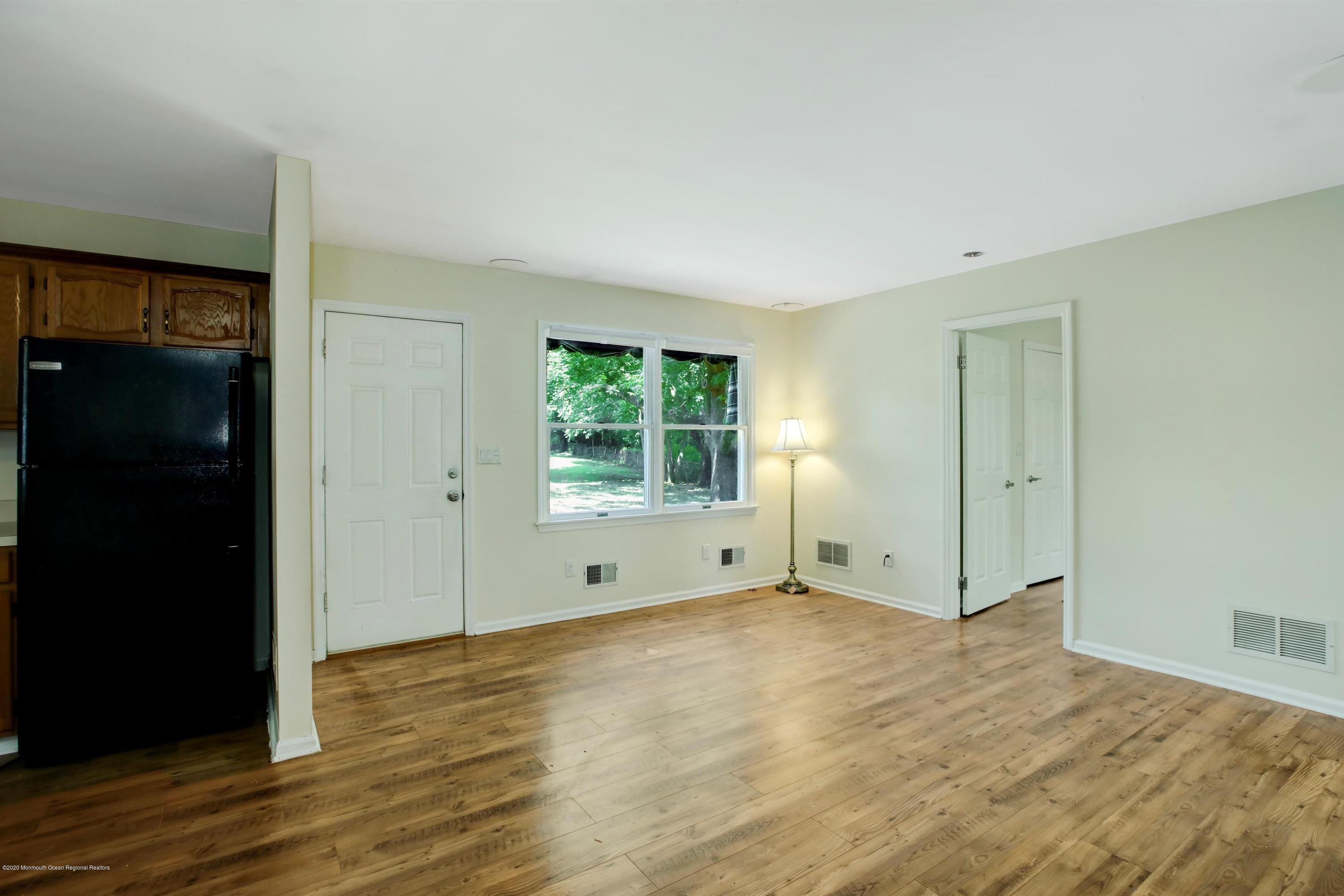 474 E Road Belford, NJ 07718 - Photo 18 of 32 a view of an empty room with wooden floor and a window