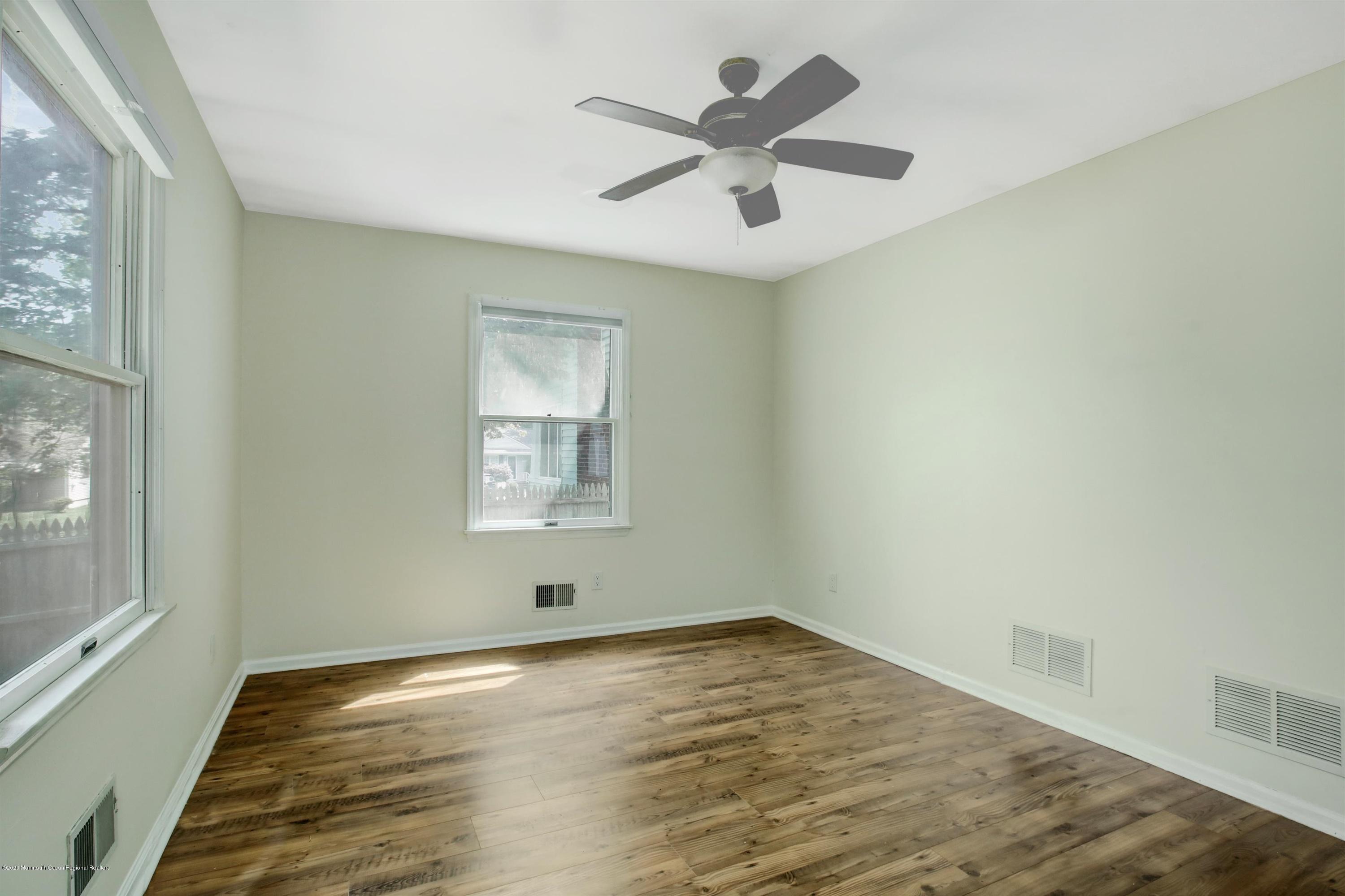 474 E Road Belford, NJ 07718 - Photo 19 of 32 an empty room with wooden floor and windows
