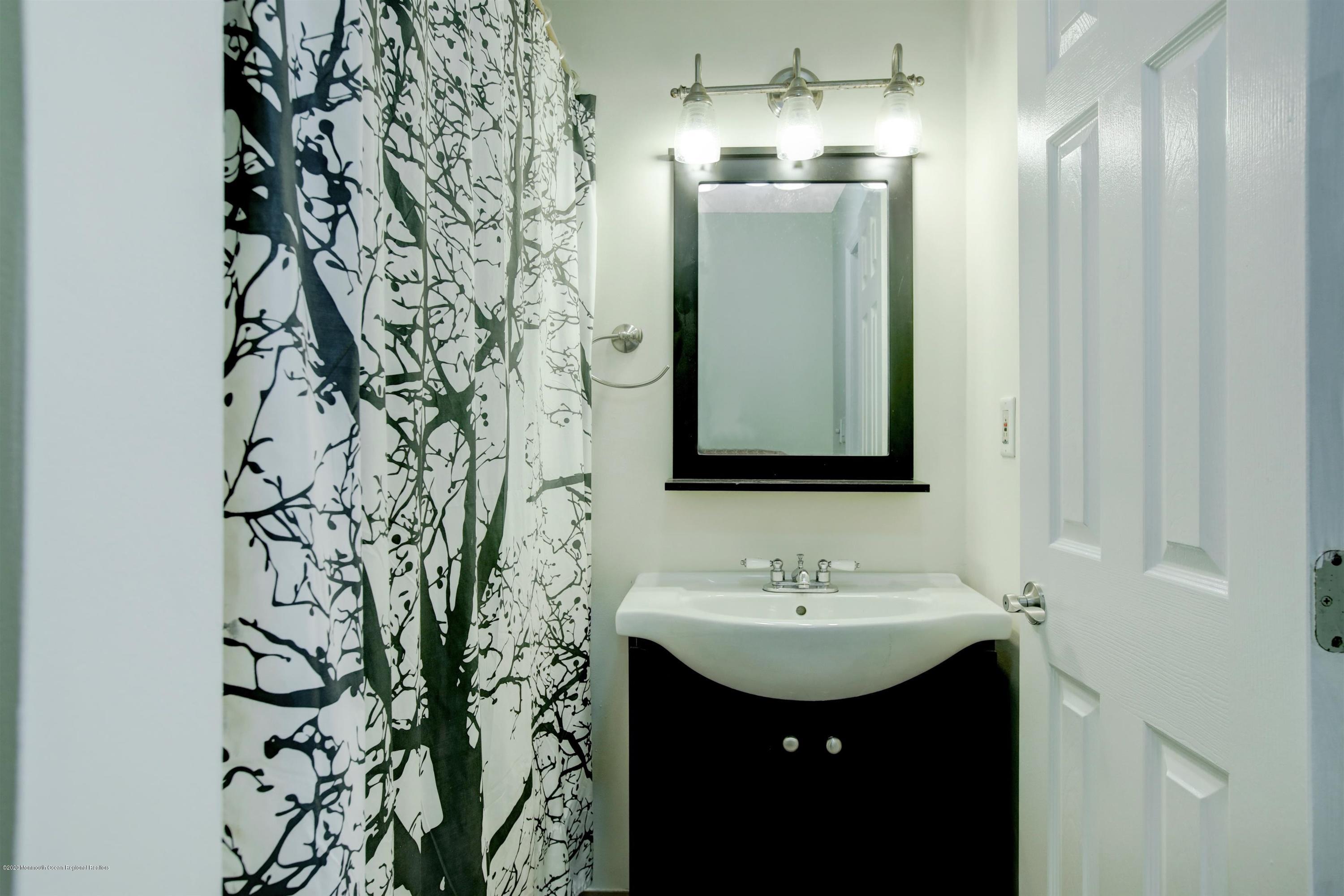 474 E Road Belford, NJ 07718 - Photo 20 of 32 a bathroom with a sink and mirror