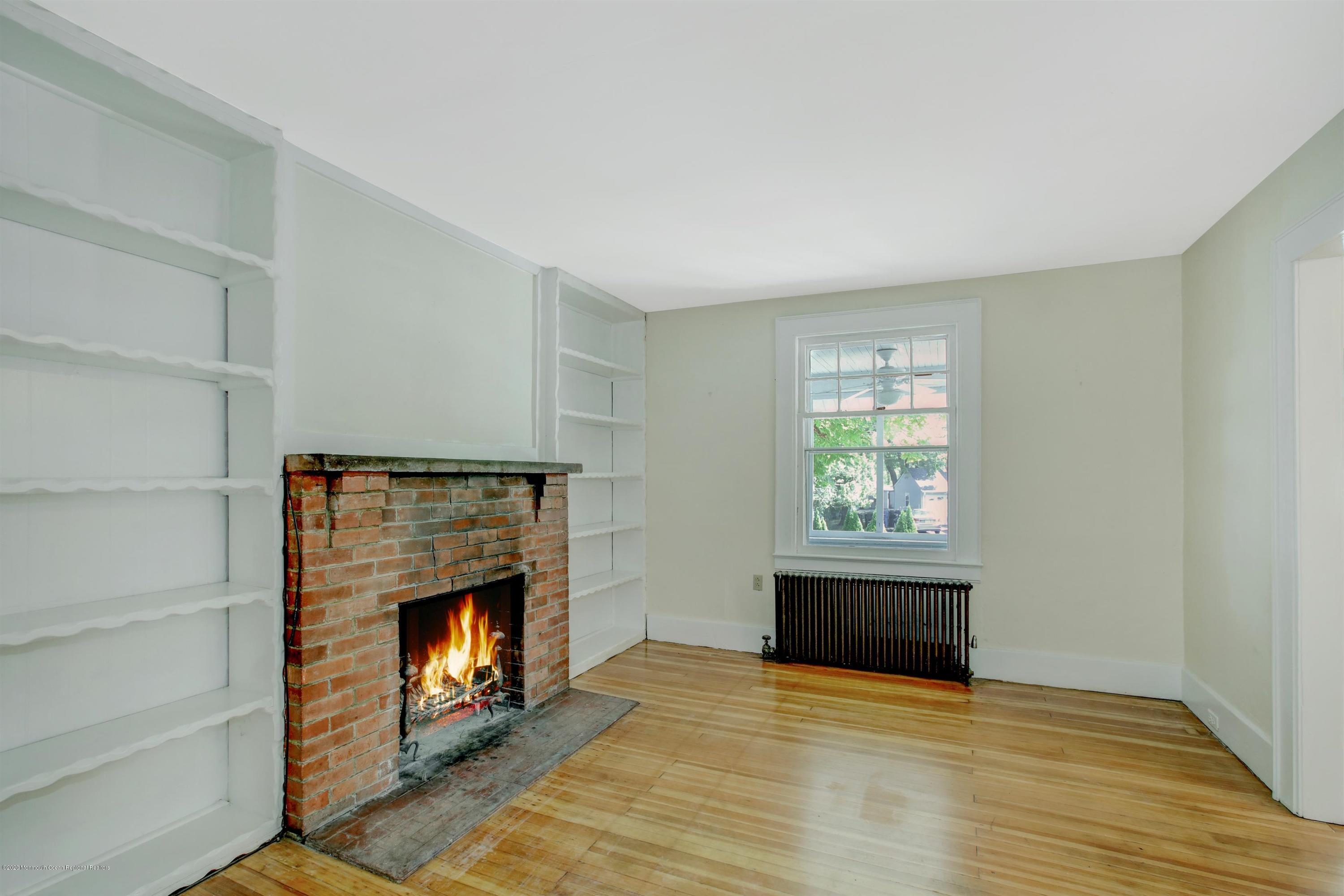 474 E Road Belford, NJ 07718 - Photo 4 of 32 a living room with a fireplace and a window