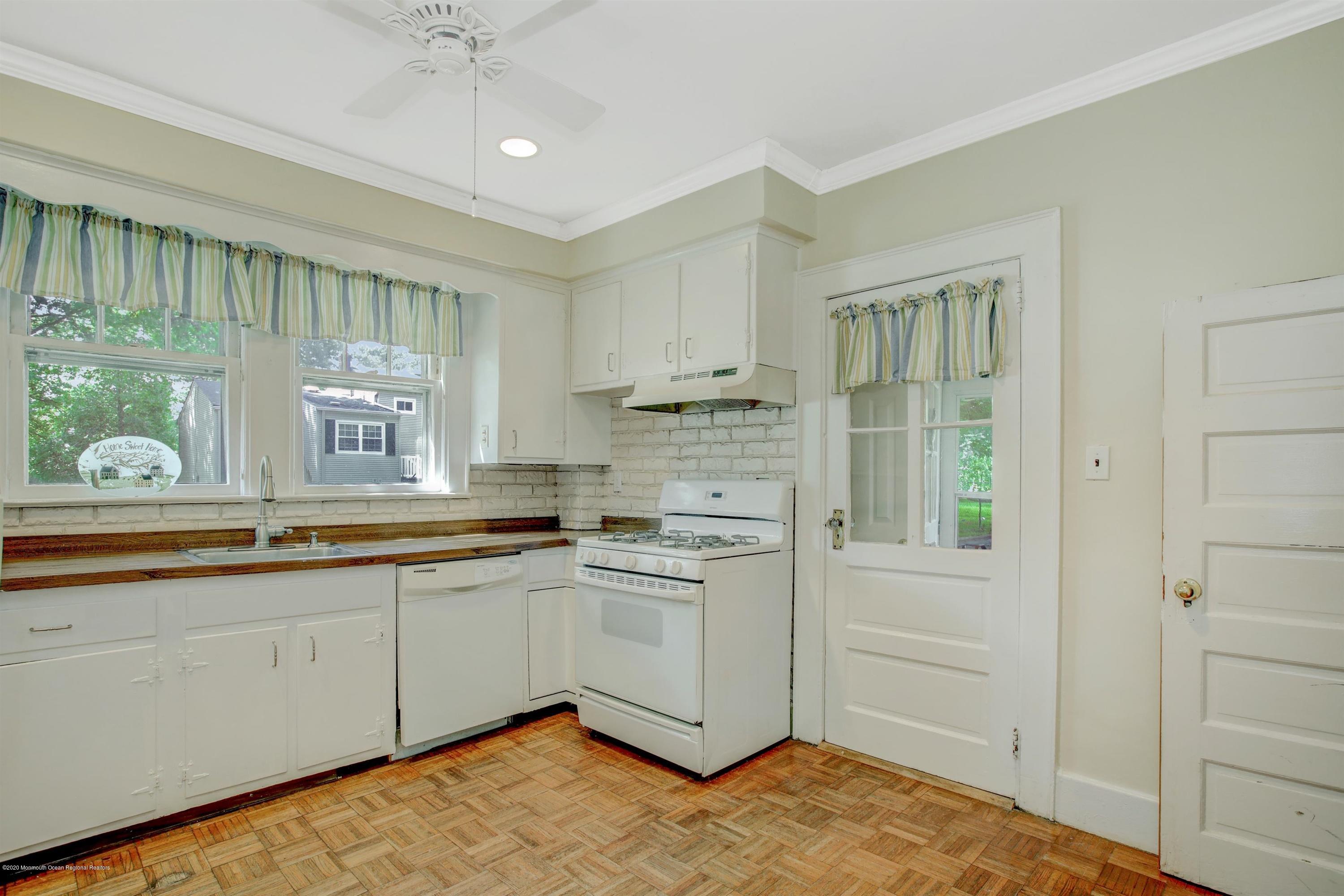 474 E Road Belford, NJ 07718 - Photo 8 of 32 a kitchen with stainless steel appliances granite countertop a sink and cabinets with wooden floor