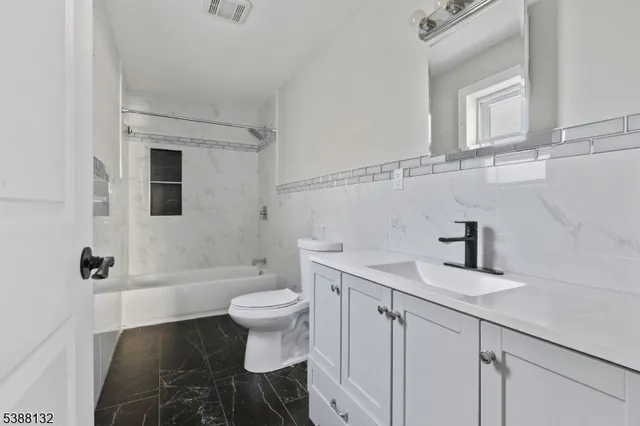 a bathroom with a sink toilet a mirror and shower