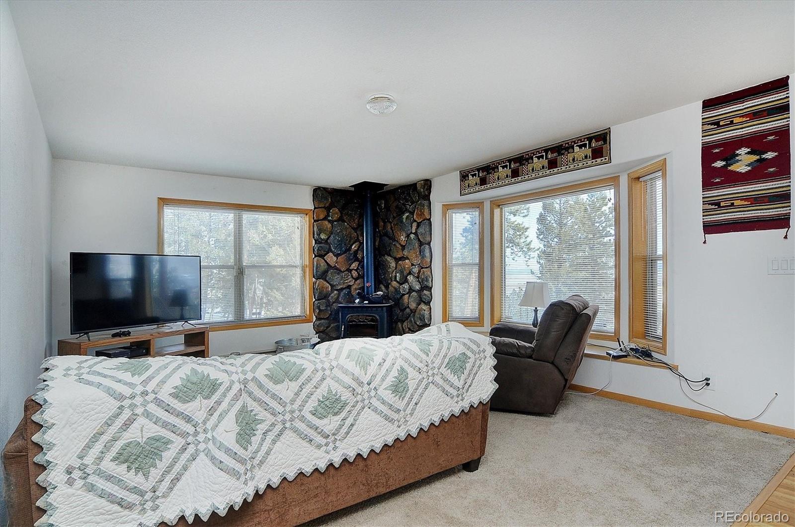 1733 Blacksmith Road Hartsel, CO 80449 - Photo 7 of 22 a bedroom with a large bed and a flat tv screen