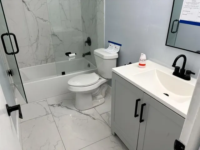 a view of an empty room with wooden floor and closet