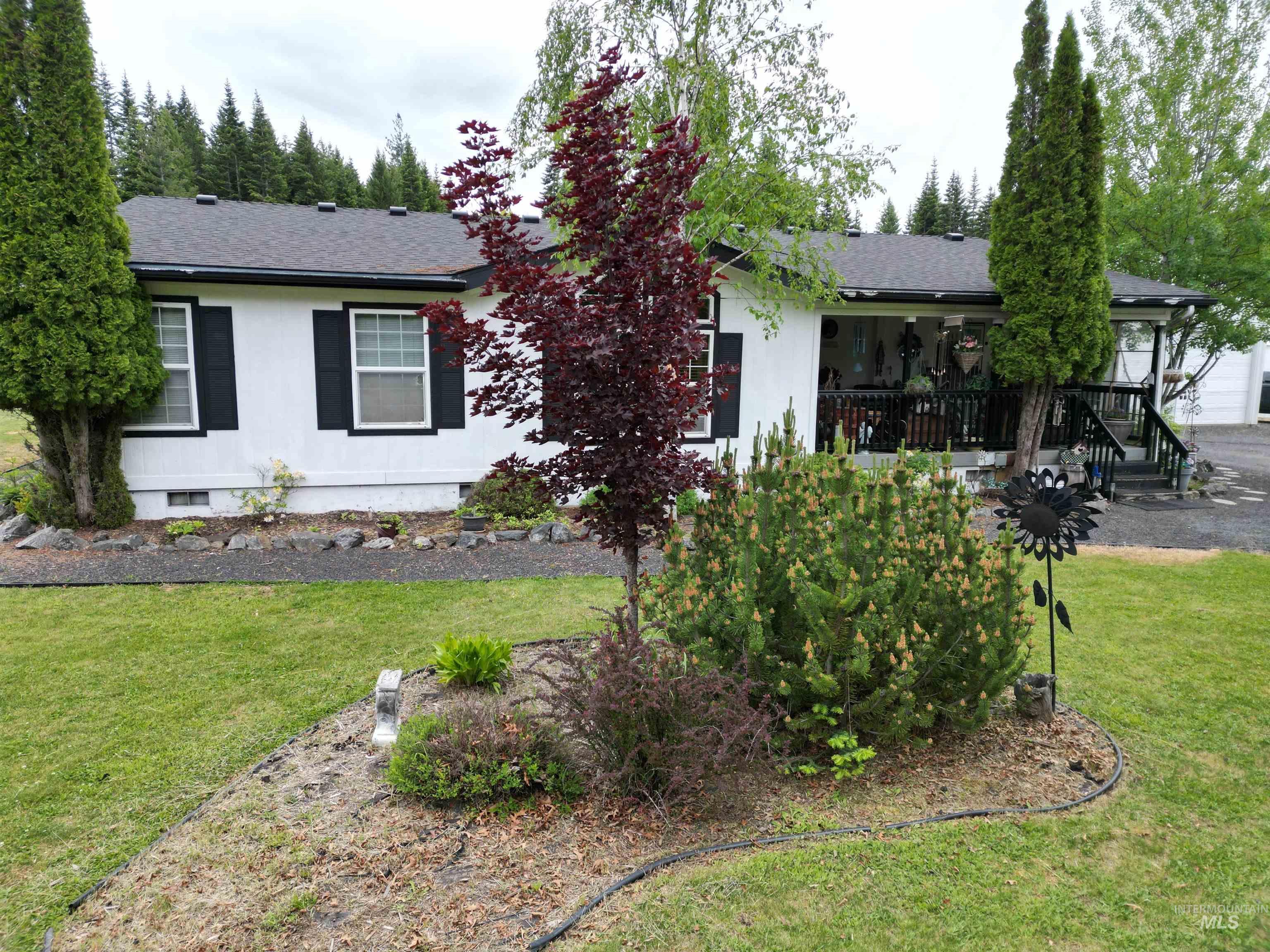 254 Lackey Road Weippe, ID 83553 - Photo 27 of 38 White exterior with black window shutters and a dark shingle roof