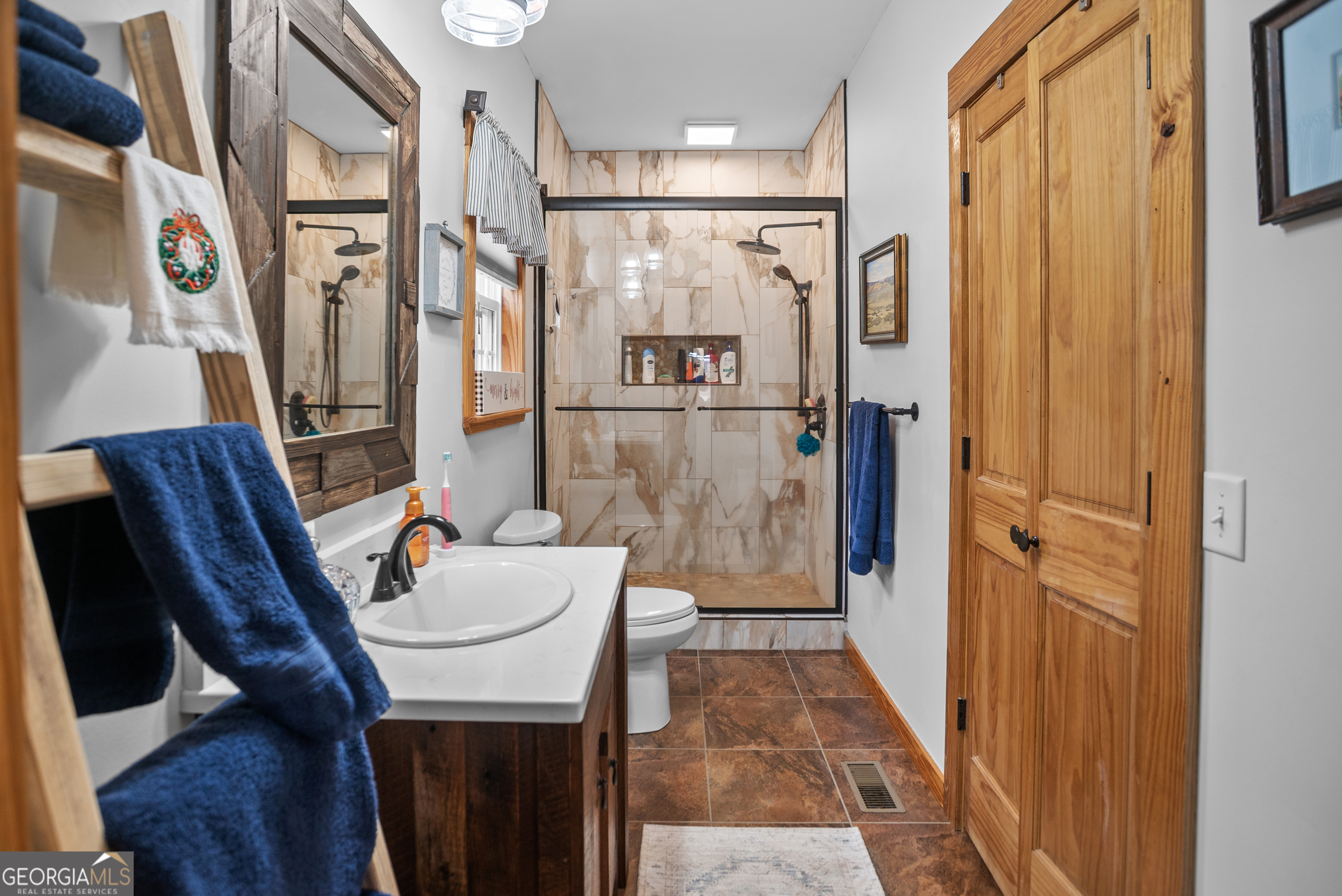 418 Oglesby Pond Road Portal, GA 30450 - Photo 13 of 56 a bathroom with a sink a mirror and a shower