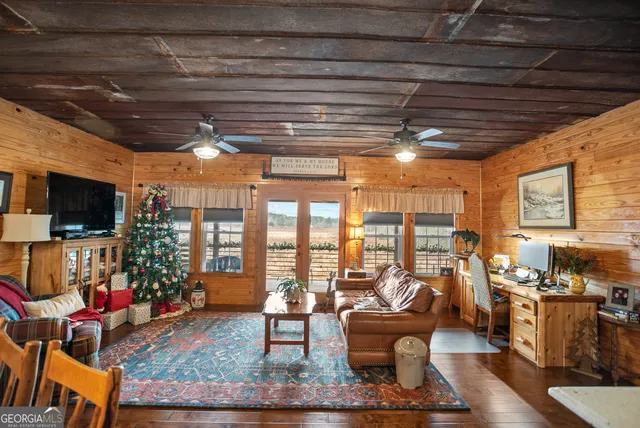 a living room with furniture a flat screen tv and a floor to ceiling window