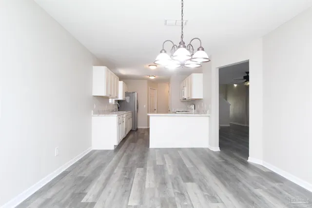 a view of a kitchen with a dishwasher and white cabinets