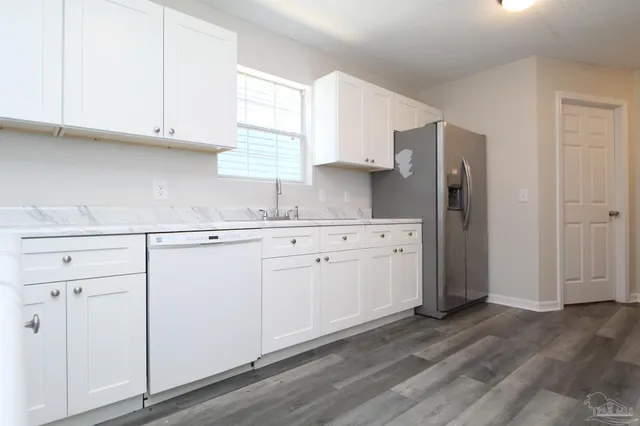 a kitchen with granite countertop white cabinets and white appliances