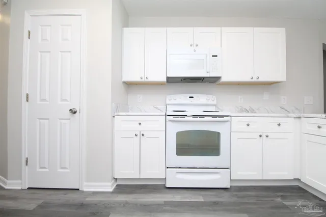a kitchen with white cabinets and white appliances