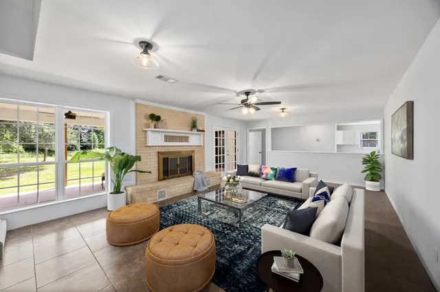 a living room with furniture a fireplace and a floor to ceiling window