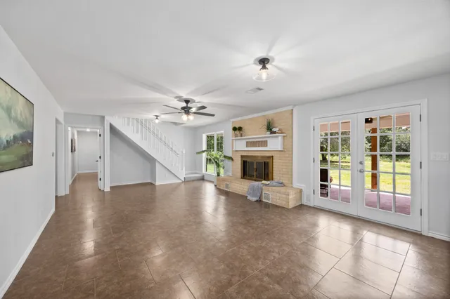 a view of an empty room with wooden floor and a fireplace