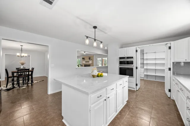a kitchen with stainless steel appliances a kitchen island hardwood floor and a sink