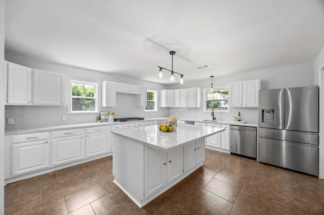 a kitchen with white cabinets and refrigerator