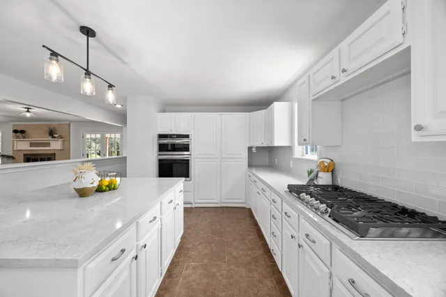 a kitchen with a sink a stove and chairs