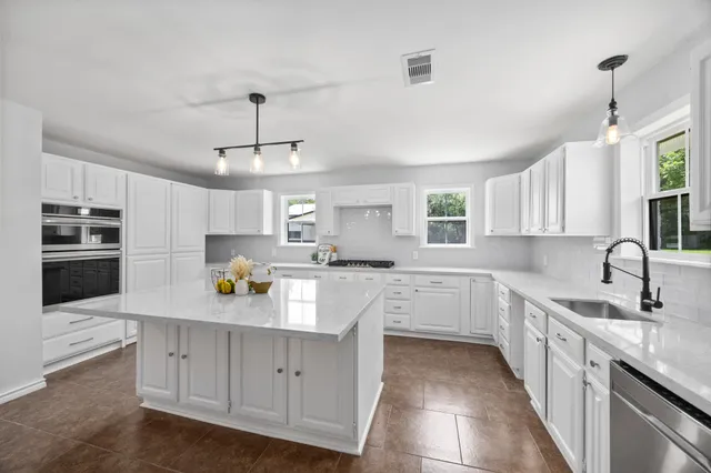 a kitchen with a white cabinets and window