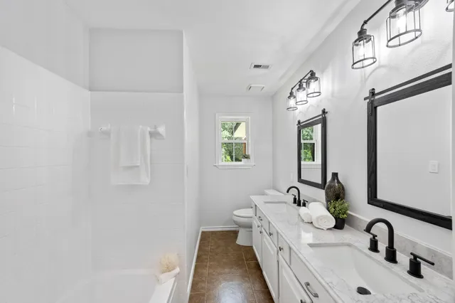 a bathroom with a double vanity sink and a bathtub