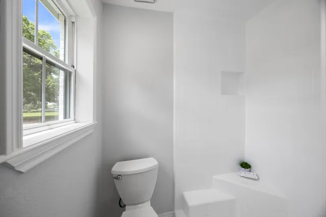 a white toilet sitting next to a window