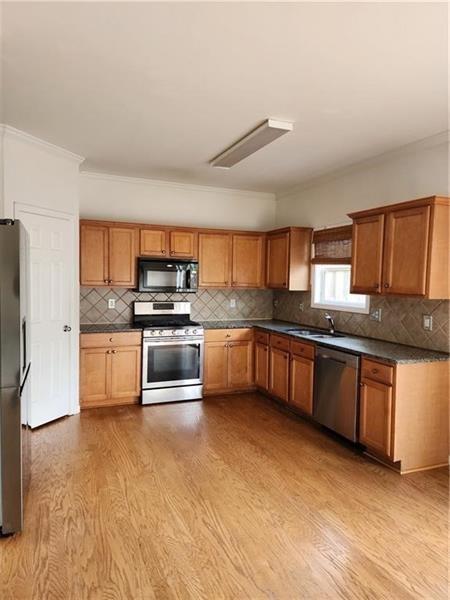 5079 Sherwood Way Cumming, GA 30040 - Photo 6 of 14 a kitchen with stainless steel appliances kitchen island granite countertop a stove a sink and a refrigerator