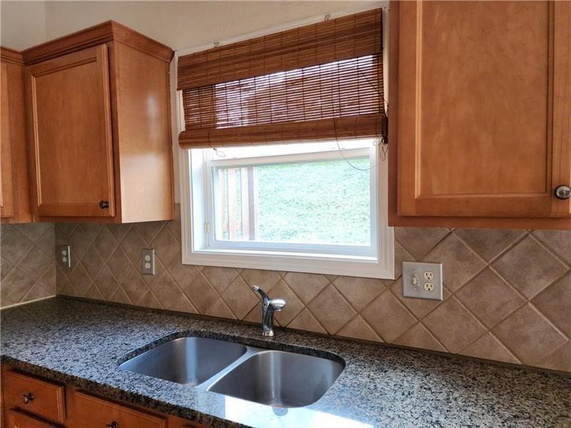 5079 Sherwood Way Cumming, GA 30040 - Photo 8 of 14 a kitchen with granite countertop a sink and a window