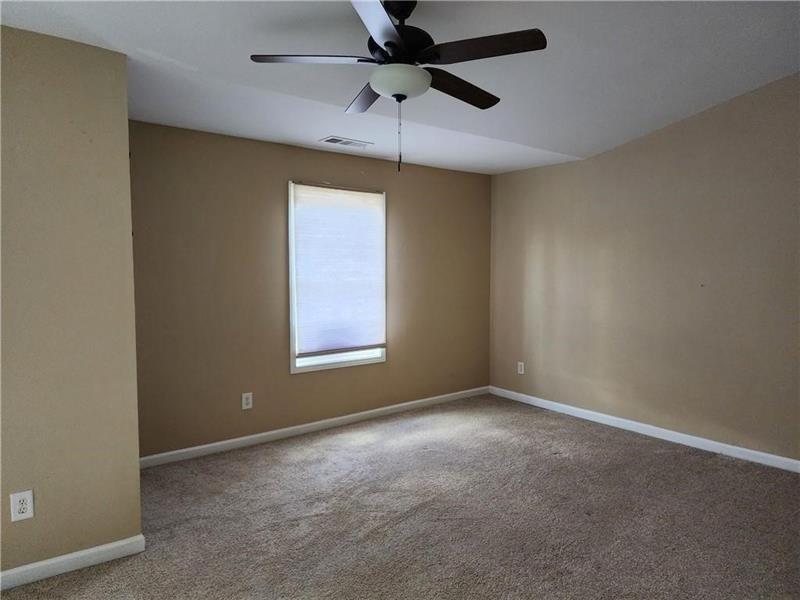 5079 Sherwood Way Cumming, GA 30040 - Photo 10 of 14 an empty room with a window and a fan