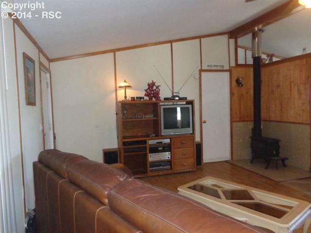 4665 North Log Road Peyton, CO 80831 - Photo 6 of 13 Living room showing cozy stove which provides warmth any time of the year!