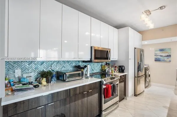 a kitchen with stainless steel appliances granite countertop a sink and a stove
