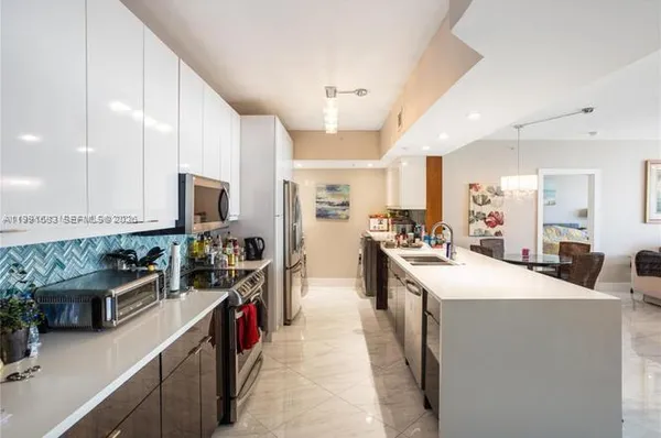 a kitchen with stainless steel appliances a sink stove top oven and cabinets
