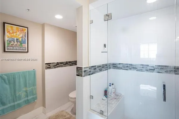 a bathroom with a shower a mirror and a toilet