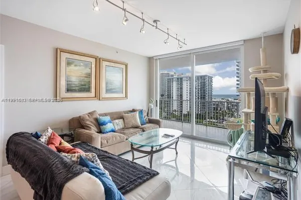 a living room with furniture and a floor to ceiling window