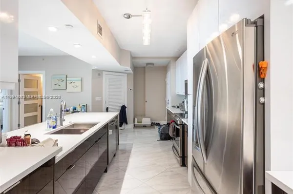 a kitchen with refrigerator and car parked
