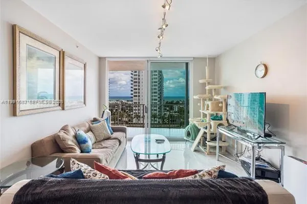 a living room with furniture a flat screen tv and a large window