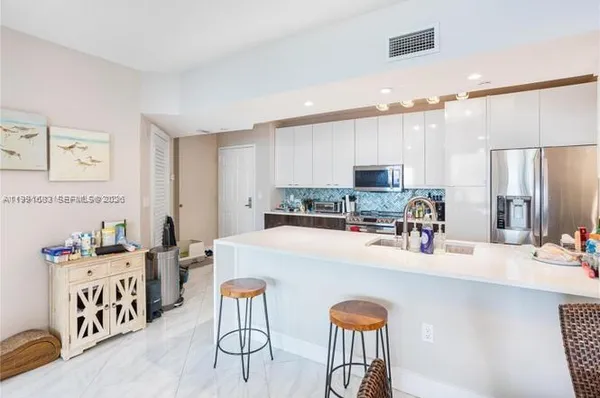 a kitchen with stainless steel appliances kitchen island granite countertop a sink and cabinets