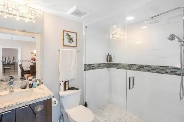 a bathroom with a granite countertop sink mirror vanity and toilet