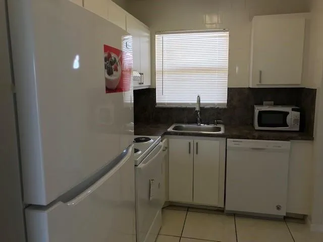 a kitchen with a refrigerator and a stove top oven