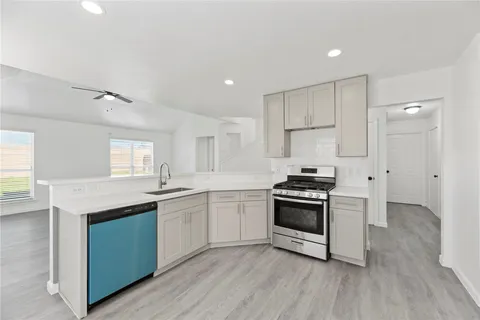 a kitchen with stainless steel appliances granite countertop a stove a sink and a refrigerator