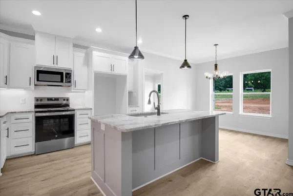 a kitchen with kitchen island a sink stainless steel appliances and cabinets
