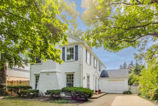a white house with a tree in front of it