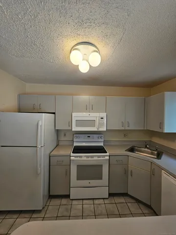 a kitchen with a stove a sink and a refrigerator