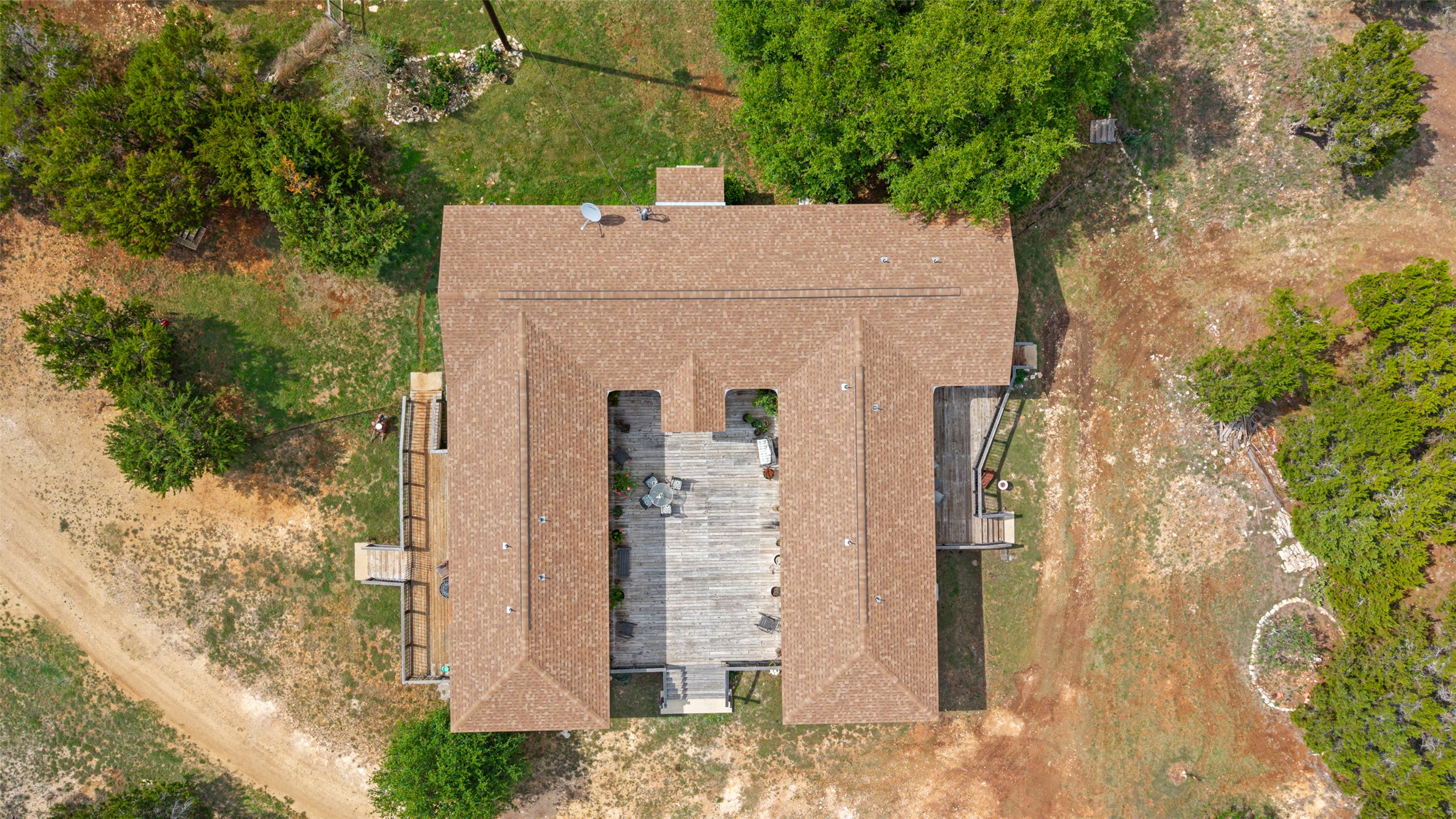 2966 Rm 165 Dripping Springs Dripping Springs, TX 78620 - Photo 4 of 23 Aerial perspective showcasing a sprawling property featuring a multi-gabled roof and a central outdoor living area