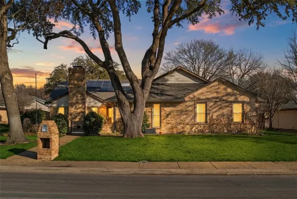 a view of a yard in front of a house with a large tree