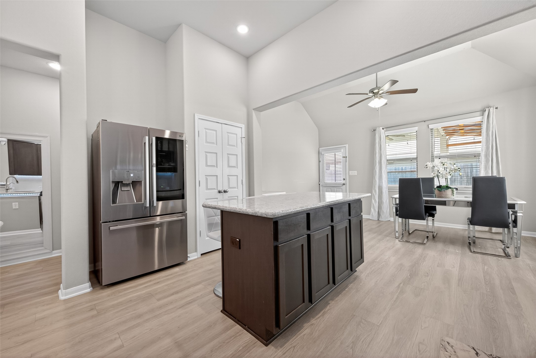22409 Kinley Street New Caney, TX 77357 - Photo 20 of 46 a kitchen with stainless steel appliances a refrigerator a sink dishwasher a stove and a dining table with wooden floor