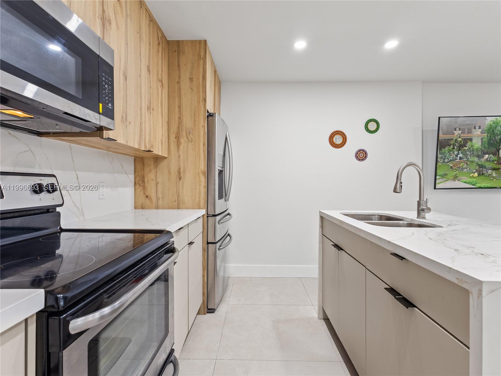 10017 Southwest 23rd Terrace Miami, FL 33165 - Photo 12 of 25 a kitchen with a sink and a stove top oven