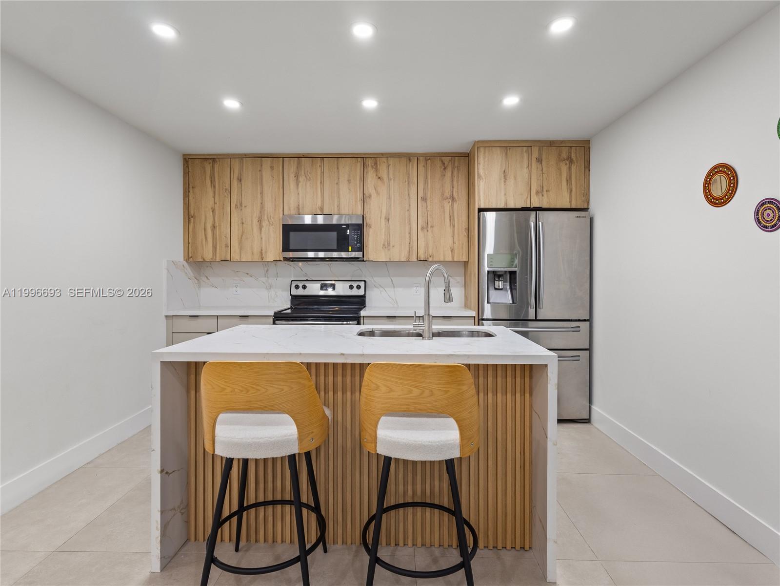 10017 Southwest 23rd Terrace Miami, FL 33165 - Photo 13 of 25 a kitchen with stainless steel appliances granite countertop a refrigerator a stove a sink dishwasher with a dining table and chairs