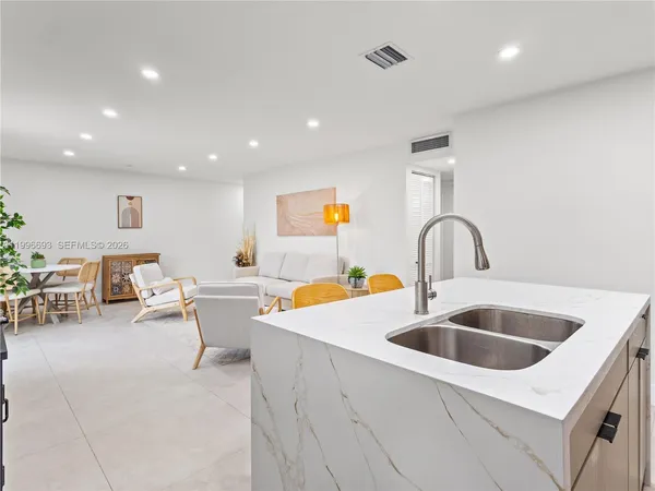 a kitchen with kitchen island granite countertop wooden cabinets a stove a sink and a refrigerator
