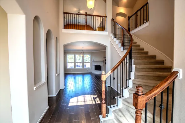 a view of an empty room with wooden floor fireplace and a window